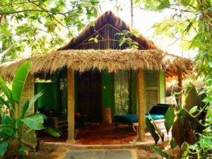 Ökologisch gestaltete Unterkunft mit natürlichen Materialien: Halb-offene Zimmer unter Palmen im Ökoresort Bhakti Kutir in Goa, Indien