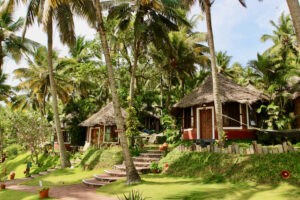 Beautiful small and luxurious garden huts in the shade of the coconut palm trees near the sea.